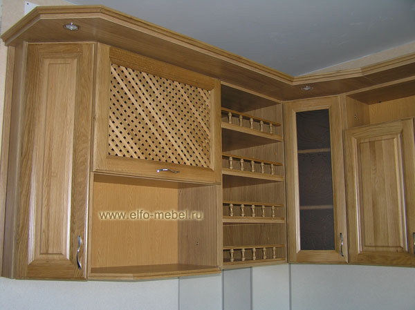 Левый верхний шкаф классической кухни с декоративными деревянными фасадами и подсветкой